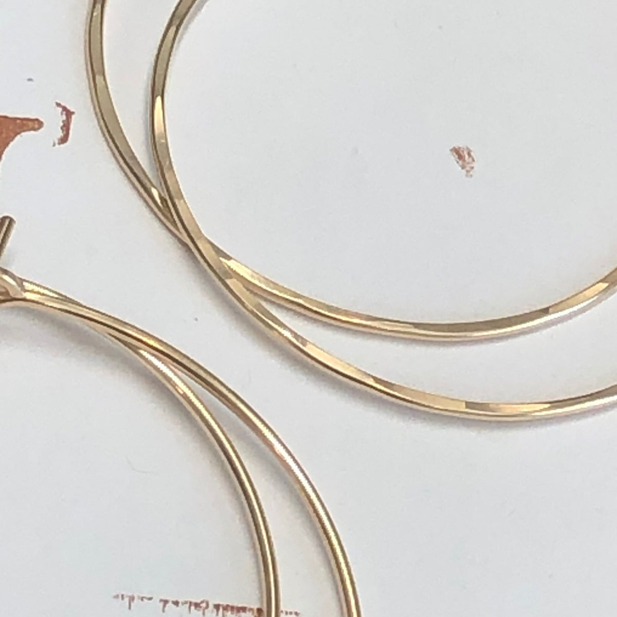 18 guage 14k gold filled hoop earrings. close up showing hammering detail of round threader hoop earrings. Laurane Elisabeth specializing in delicate, lightweight minimalist jewelry. Always nickel free.